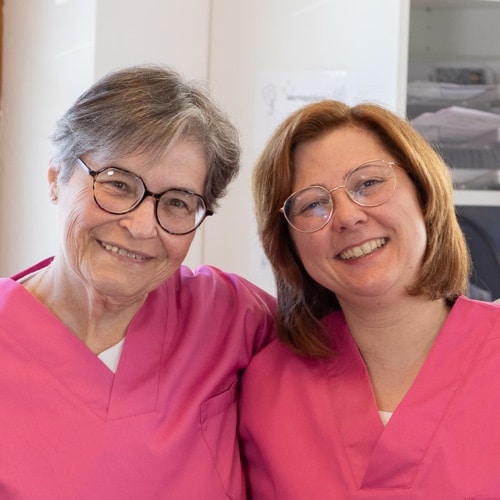 L&auml;chelnde Frau mit Hand aufs Herz.