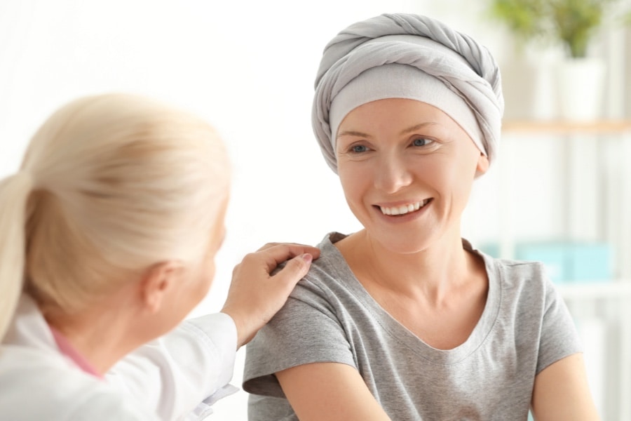 A woman consoles another having chemotherapy